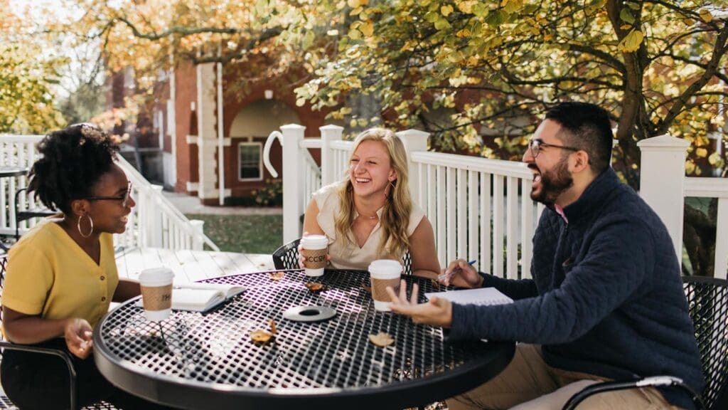 Students talking and laughing around a picnic table
