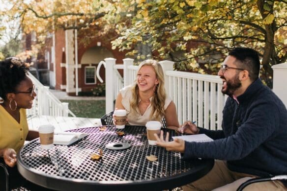 Students talking and laughing around a picnic table
