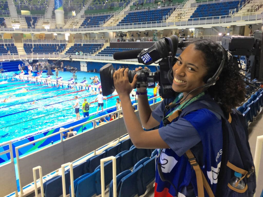 Media communications student filming indoor swimming