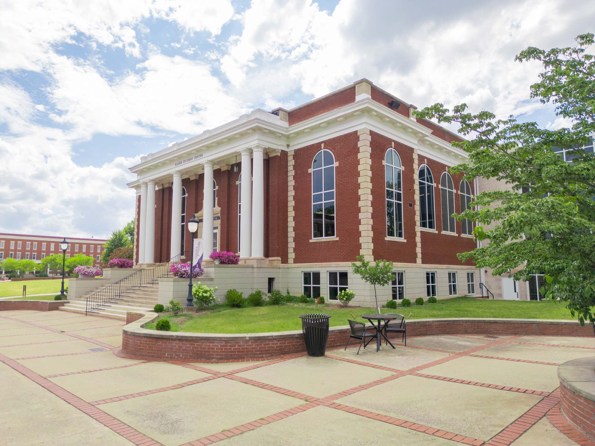 Front entrance of the Paul A. and Kay F. Rader Student Center (The STUCE) at Asbury University, featuring red brick, white trim, and a columned portico with grand stairs.