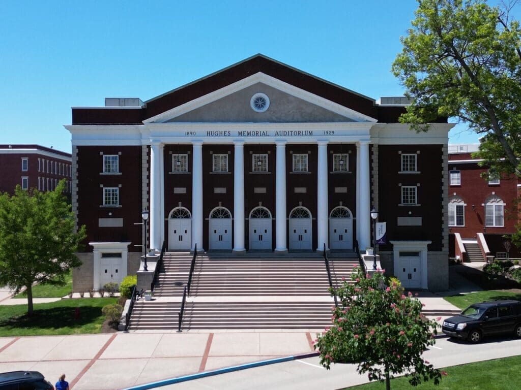 Front entrance of Hughes Auditorium at Asbury University with classical columns and a pediment featuring an inscribed circle.