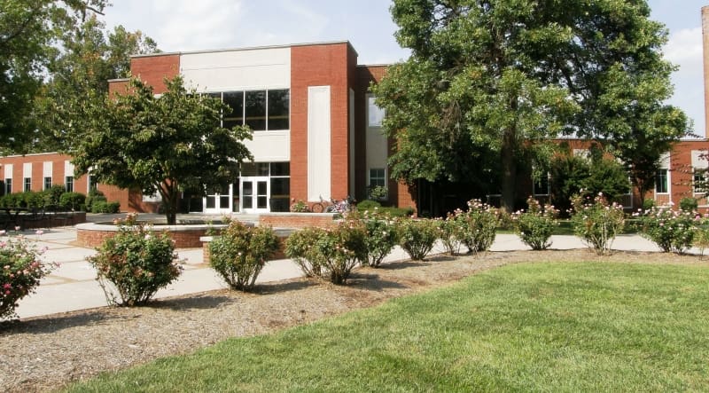 Exterior entrance of the Johnson Building at Asbury University, a modern structure with large windows, housing dining and art gallery.