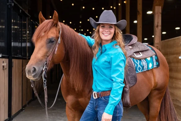 Asbury University alumna Clara Quade ’20 standing beside her horse Ruby after Central Ohio Reining Horse Association named her the 2025 Rookie Professional Champion.