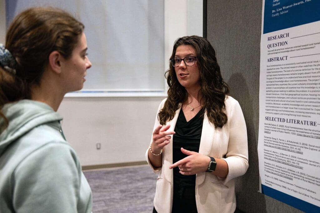 Asbury University student presenting to another student.