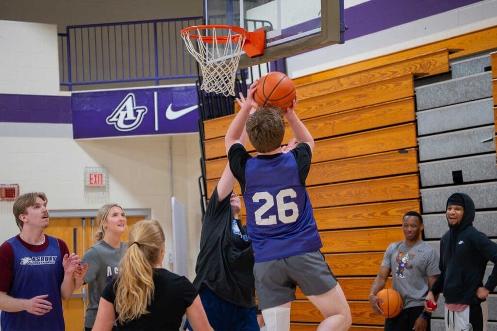 Asbury co-ed basketball intramurals with student about to make a shot.