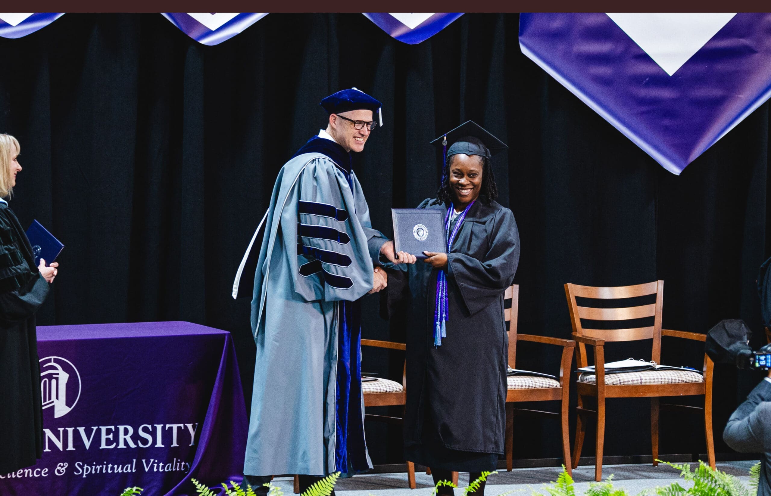 Asbury University online graduate presented disploma from Asbury President Kevin Brown.