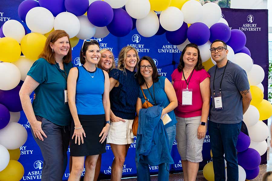 Group of Asbury Alumni standing in front of a balloon arch at Reunion.