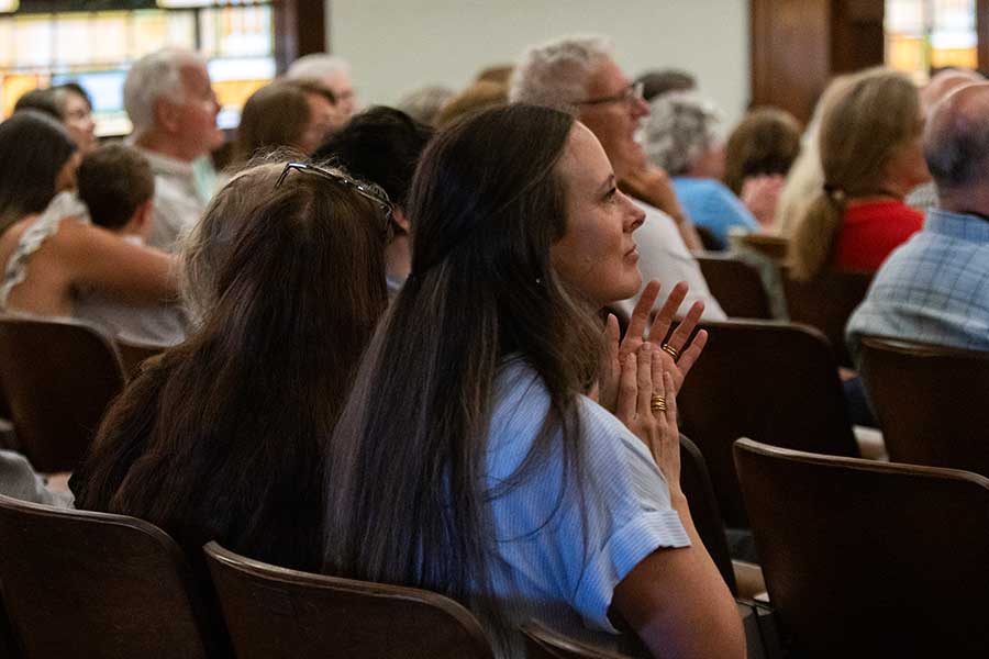 Woman focused in prayer at hymn sing at Asbury's Reunion.