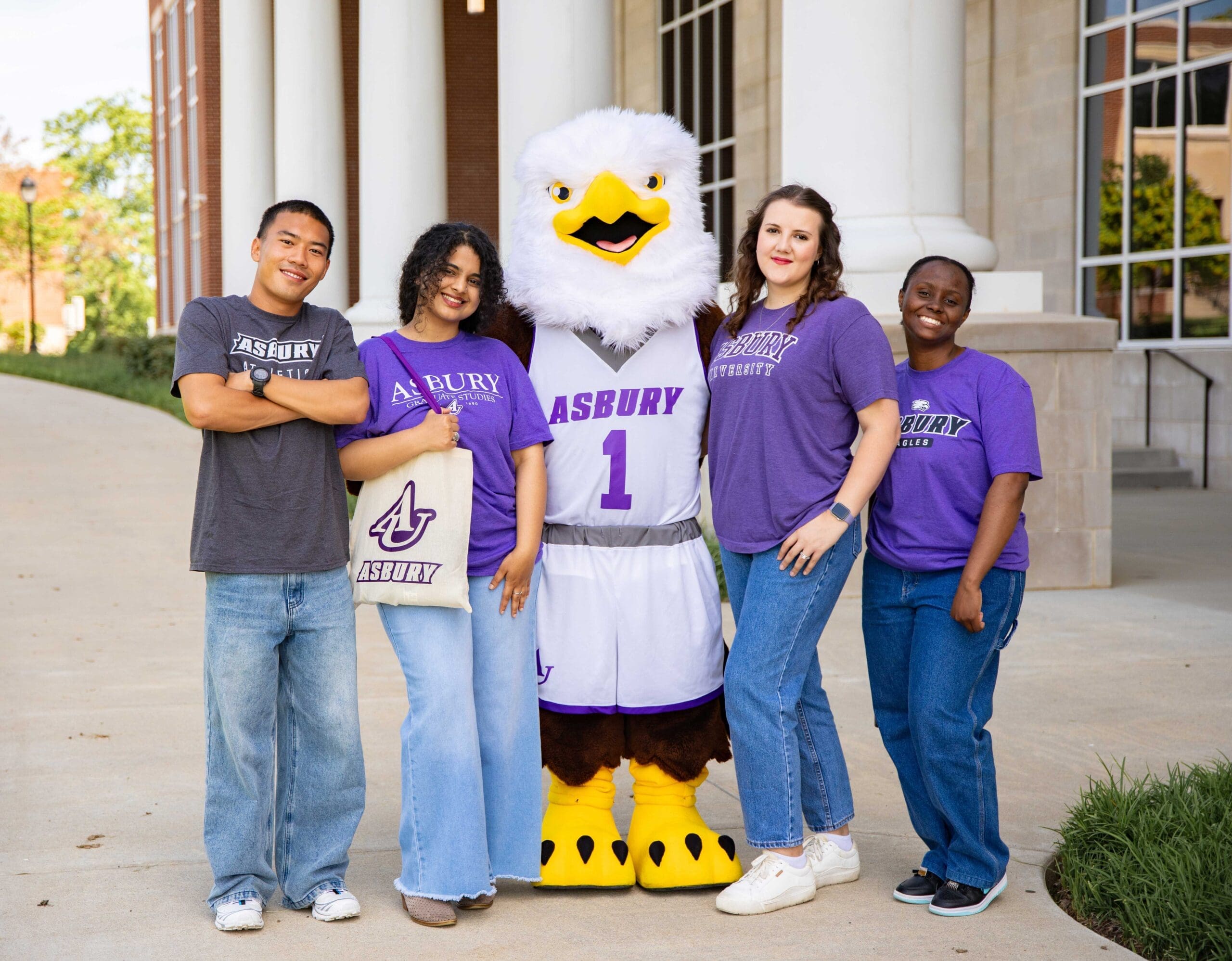 Group of Asbury students standing with Isaiah the Eagle mascot.