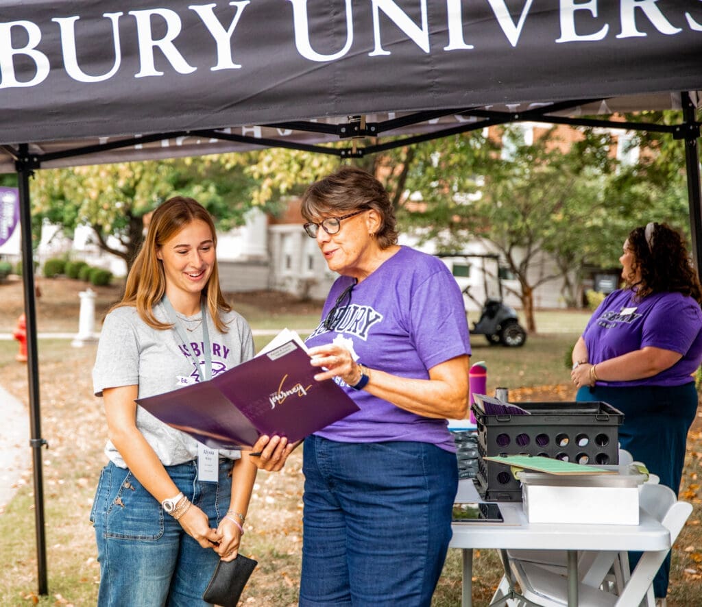 A new Asbury freshman gets guidance from a volunteer with a clipboard.