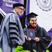 Asbury University President Dr. Kevin Brown smiles with graduating student at Commencement