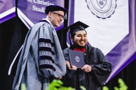 Asbury University President Dr. Kevin Brown smiles with graduating student at Commencement