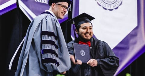 Asbury University President Dr. Kevin Brown smiles with graduating student at Commencement