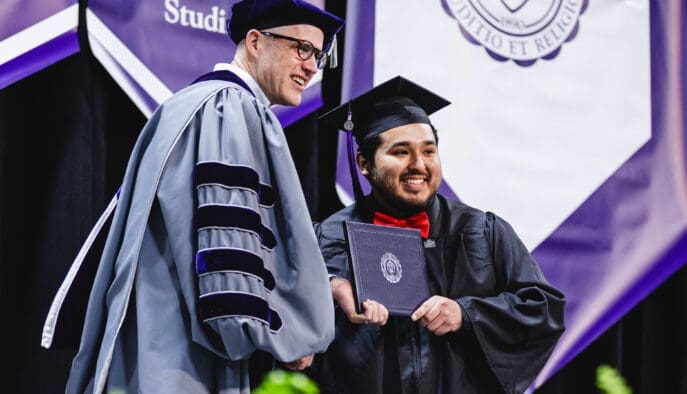 Asbury University President Dr. Kevin Brown smiles with graduating student at Commencement