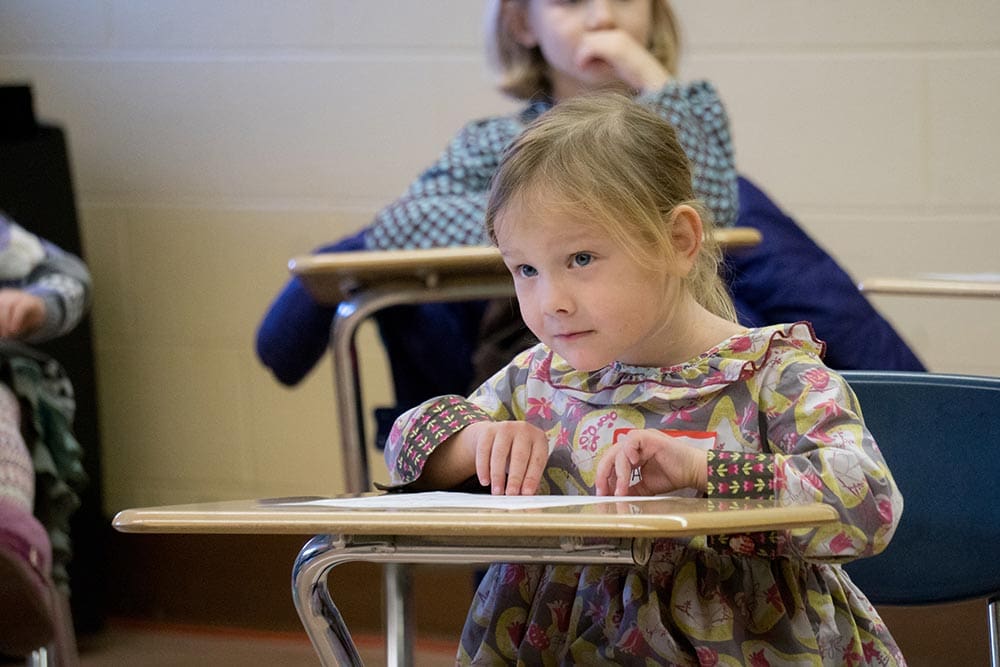 child listening at a desk