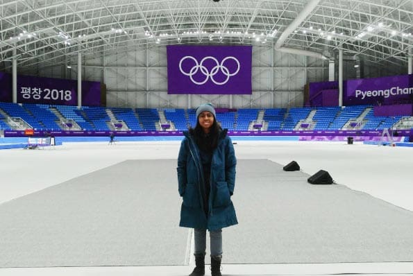Student standing on an Olympic ice rink