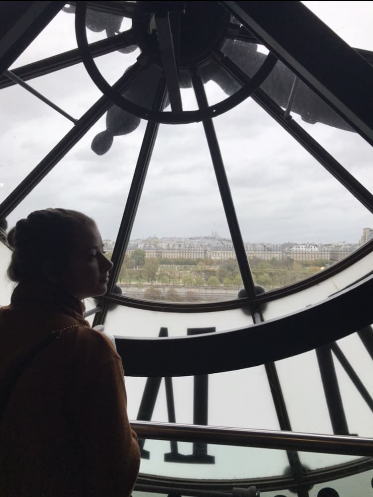 Student in a clock tower behind the clock face