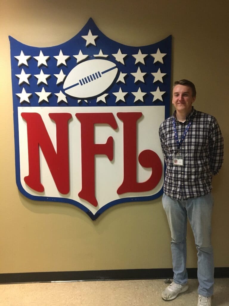 Ty Schadt ’20 standing beside the NFL logo