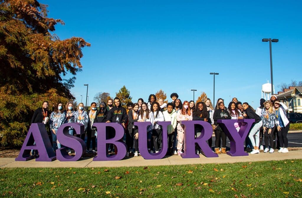 Group of students behind large letters spelling ASBURY