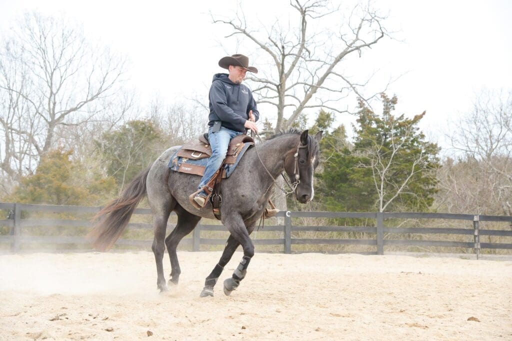 Jesse Westfall riding a horse in a corral