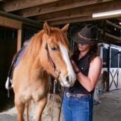 Student working with a horse in the stables