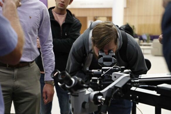 Student looking through microscope equipment