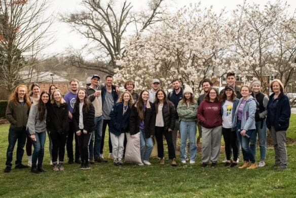 Group of students standing with trees in bloom