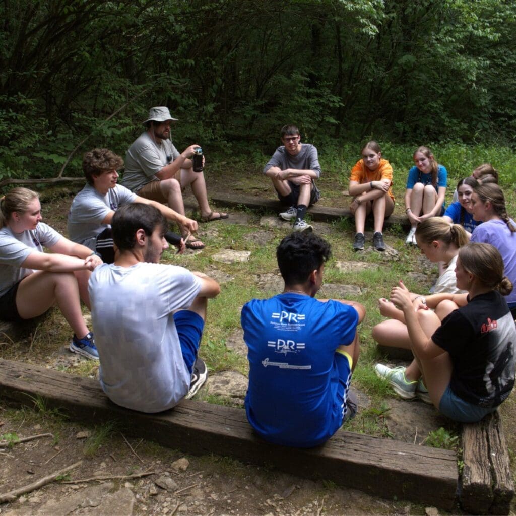 Students sitting in a circle outside