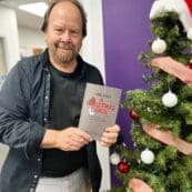 Dr. Devin Brown holding a copy of the new book he helped edit