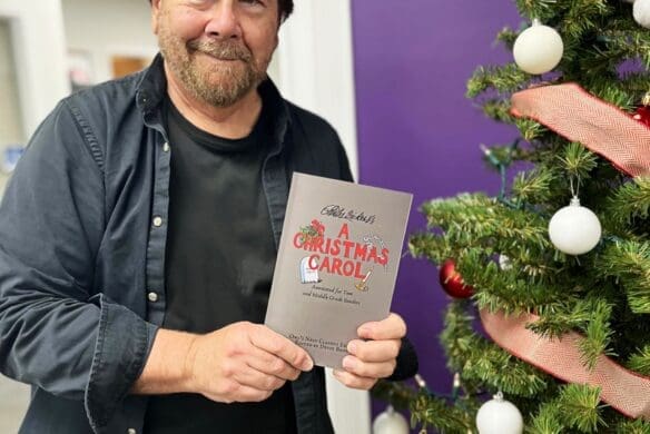 Dr. Devin Brown holding a copy of the new book he helped edit