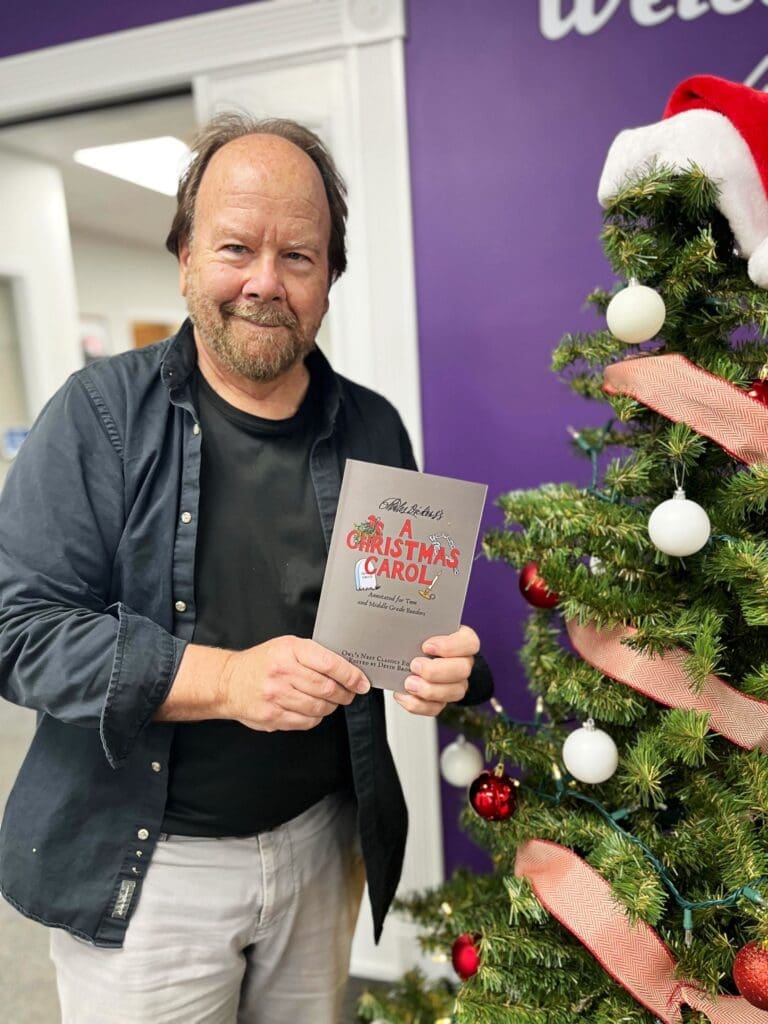 Dr. Devin Brown holding a copy of the new book he helped edit