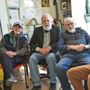 Three old men sitting in chairs