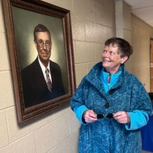 Carol Sue Ray looking a her father's portrait