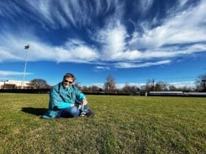 Carol Sue Ray sitting on a soccer field