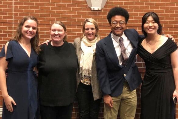 Group of students in front of a brick wall