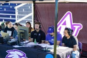 Student sports commentators at a desk