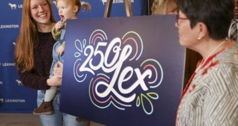 People unveiling a 250 Lex graphic design