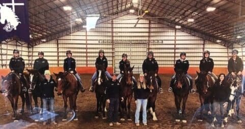 Students on horses in a riding arena