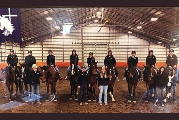 Students on horses in a riding arena