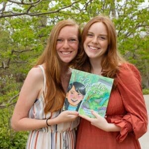 Two women holding a children's book