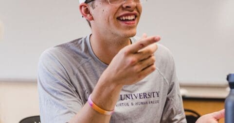 Student smiling and talking in a classroom