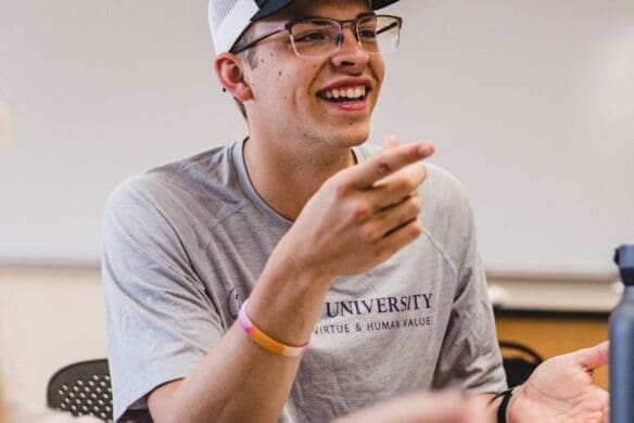 Student smiling and talking in a classroom