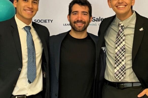 Three people standing and smiling