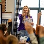 Teacher asking a question and kids raising their hands