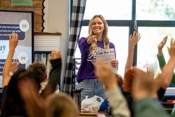 Teacher asking a question and kids raising their hands