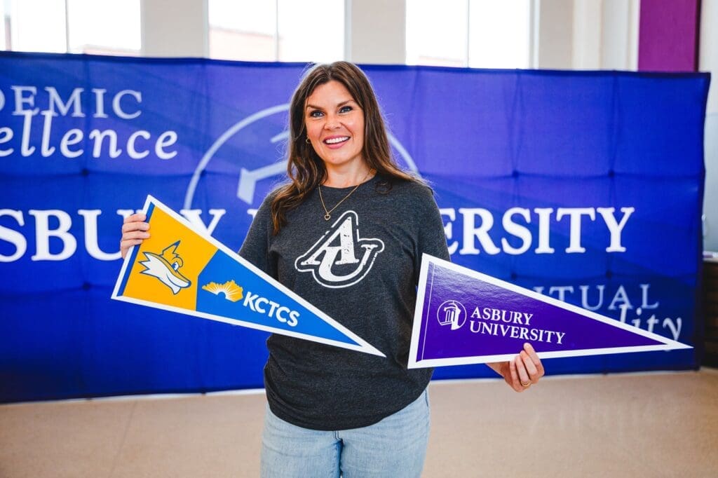 Bethany Henry holding KCTCS and Asbury banners