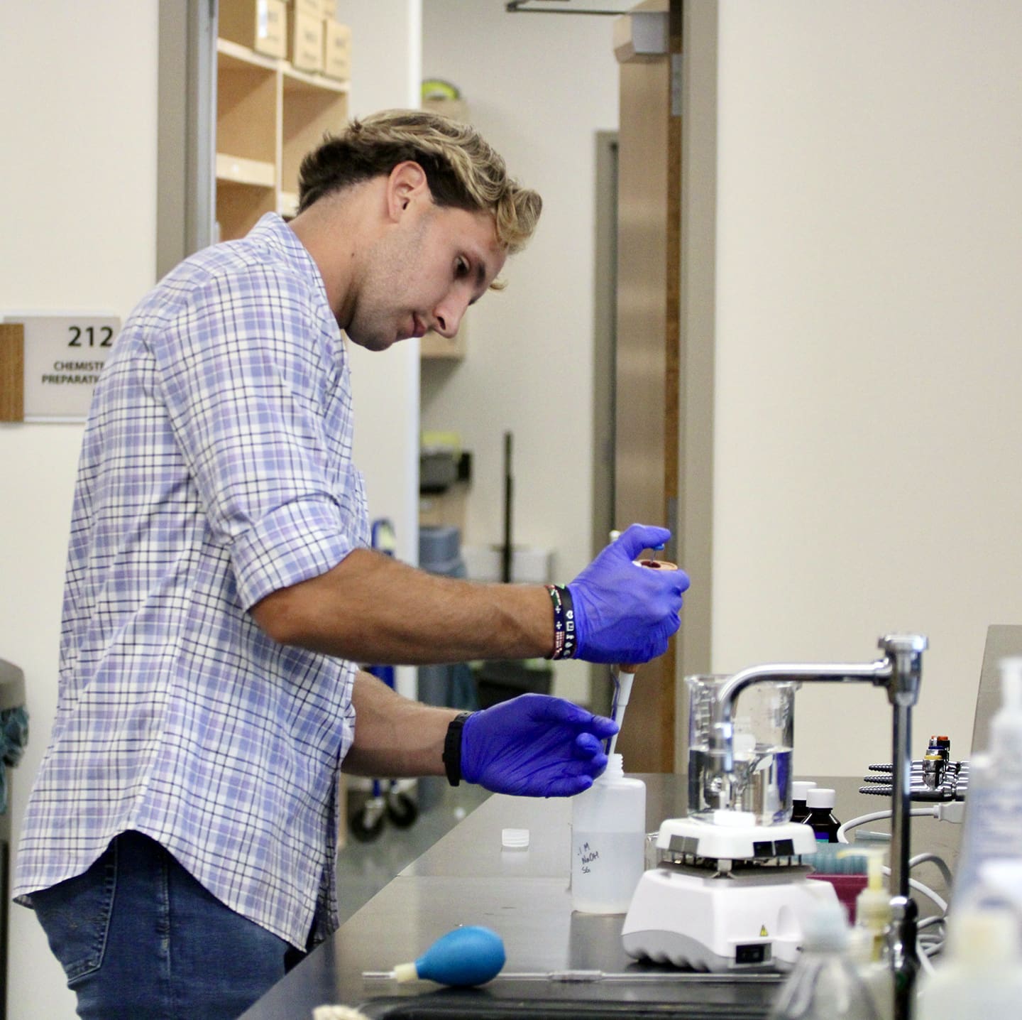 Student pipetting liquid in chemistry laboratory