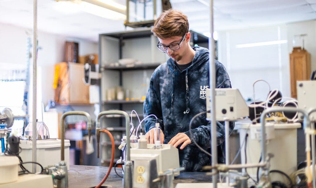 Male student uses chemistry equipment in a chemistry lab