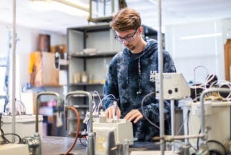 Male student uses chemistry equipment in a chemistry lab