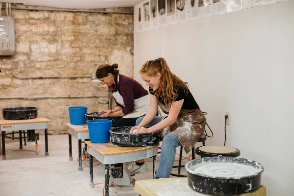 Asbury student and teacher having fun crafting at the potter's wheel.